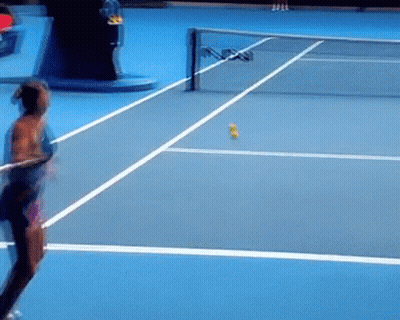 A Woman Is Swinging A Tennis Racket On A Blue Tennis Court . GIF