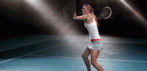 A Woman Is Swinging A Tennis Racquet On A Blue Tennis Court GIF