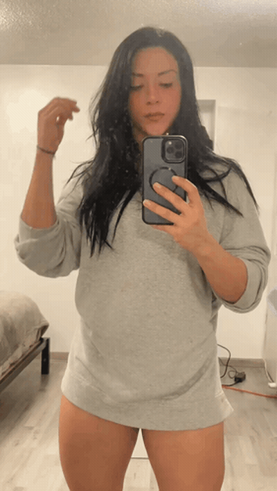 A Woman Is Taking A Picture Of Herself In A Mirror GIF