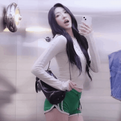A Woman Is Taking A Picture Of Herself In A Mirror GIF