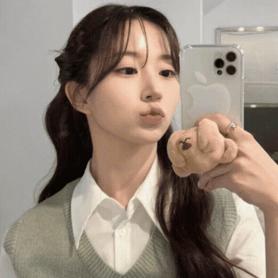 A Woman Is Taking A Picture Of Herself In A Mirror With An Apple Phone GIF
