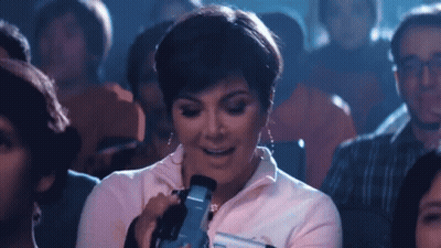 A Woman Is Taking A Picture With A Camera In A Crowded Theater GIF