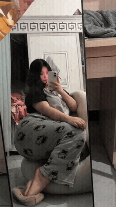 A Woman Is Taking A Selfie In Front Of A Mirror With Chinese Characters On It GIF