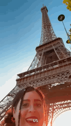 A Woman Is Taking A Selfie In Front Of The Eiffel Tower In Paris GIF