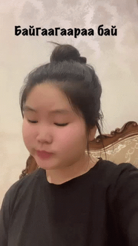 A Woman Is Taking A Selfie With A Bun In Her Hair And The Words " Baigaaagaraaa Bai " Written Above Her Head GIF