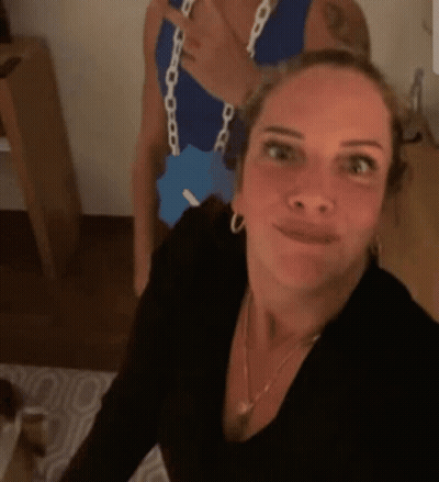 A Woman Is Taking A Selfie With A Man In A Blue Tank Top . GIF
