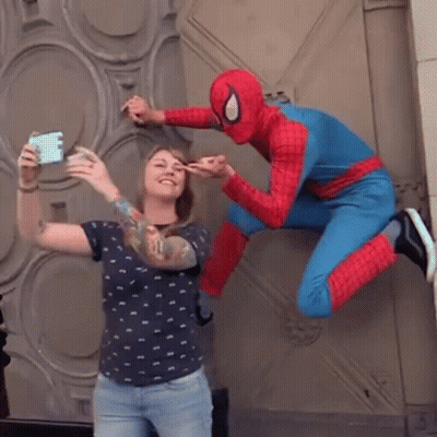 A Woman Is Taking A Selfie With A Spider Man In A Spiderman Costume GIF