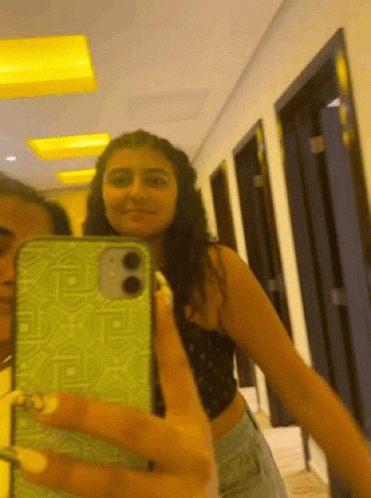 A Woman Is Taking A Selfie With Her Phone GIF