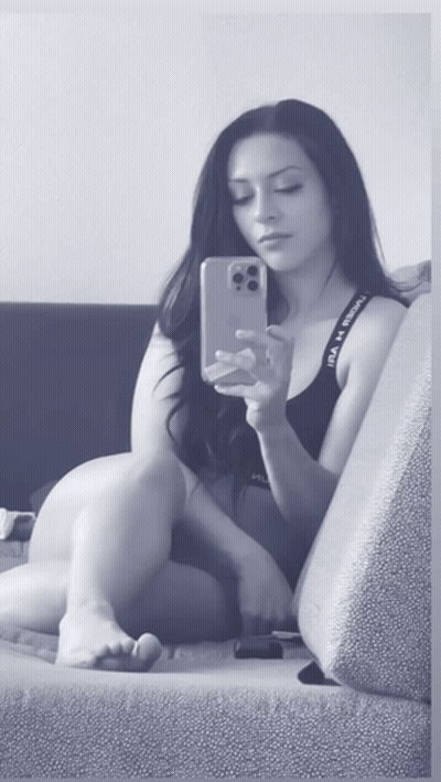A Woman Is Taking A Selfie With Her Phone While Wearing Under Armour Underwear GIF