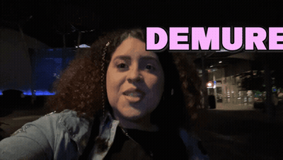 A Woman Is Taking A Selfie With The Words Demure Behind Her GIF