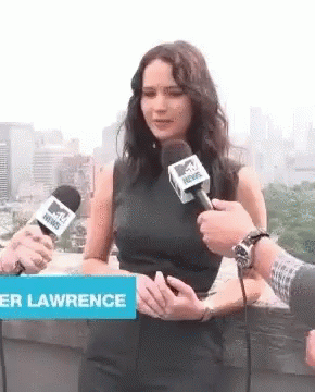 A Woman Is Talking Into A Mtv News Microphone While Standing Next To A Sign That Says Lawrence GIF