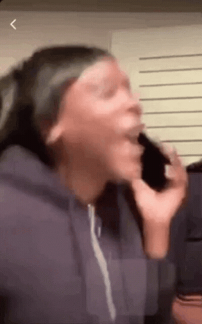 A Woman Is Talking On A Cell Phone And Making A Face . GIF