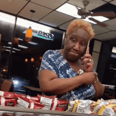 A Woman Is Talking On A Cell Phone In A Restaurant With Doritos In Front Of Her GIF
