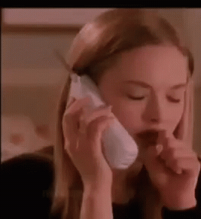 A Woman Is Talking On A Cell Phone While Holding Her Nose . GIF
