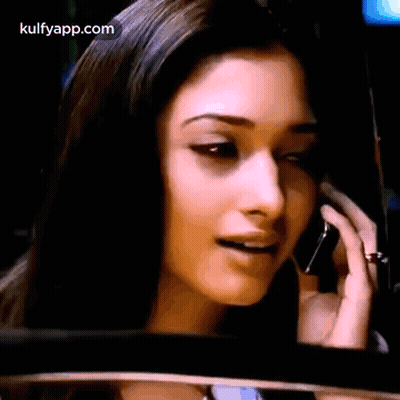 A Woman Is Talking On A Cell Phone While Looking At The Rear View Mirror . GIF