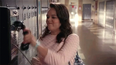 A Woman Is Talking On A Payphone In A Hallway . GIF