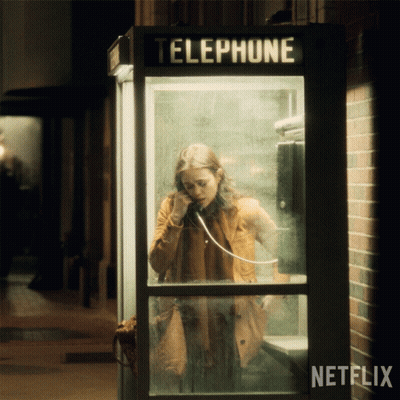 A Woman Is Talking On A Phone In A Telephone Booth With Netflix Written On The Bottom GIF