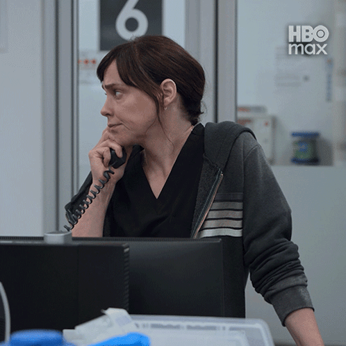 A Woman Is Talking On A Phone In Front Of A Computer With The Number 6 Behind Her GIF