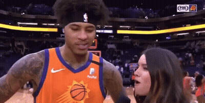 A Woman Is Talking To A Basketball Player Who Is Wearing A Paypal Jersey . GIF