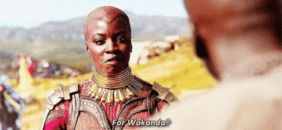A Woman Is Talking To A Man In A Field While Wearing A Necklace And Armor . GIF