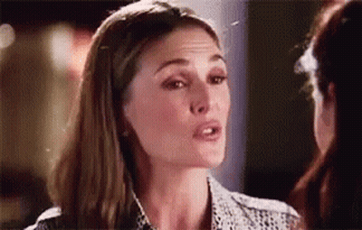 A Woman Is Talking To Another Woman In A Room And Looking At The Camera . GIF