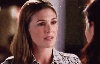 A Woman Is Talking To Another Woman While Looking At Her Face . GIF
