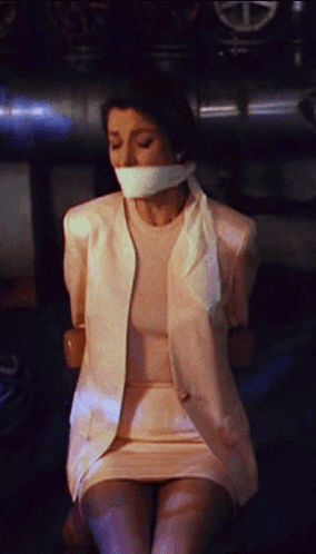 A Woman Is Tied Up With Duct Tape And Has A White Shirt On GIF