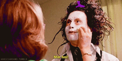A Woman Is Touching A Man 'S Face And He Says Mm-Hmm GIF