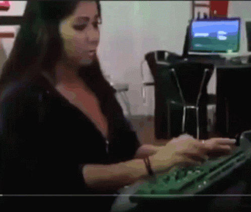 A Woman Is Typing On A Keyboard In Front Of A Computer Screen GIF