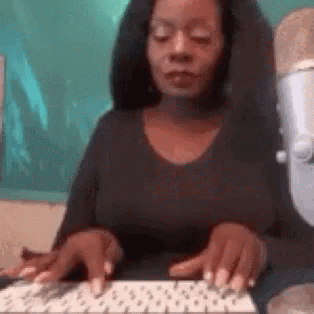 A Woman Is Typing On A Keyboard With Her Eyes Closed . GIF
