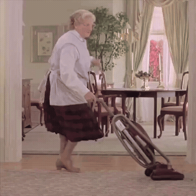 A Woman Is Using A Vacuum Cleaner To Clean The Floor In A Living Room GIF