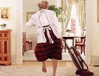 A Woman Is Using A Vacuum Cleaner To Clean The Floor In A Living Room GIF
