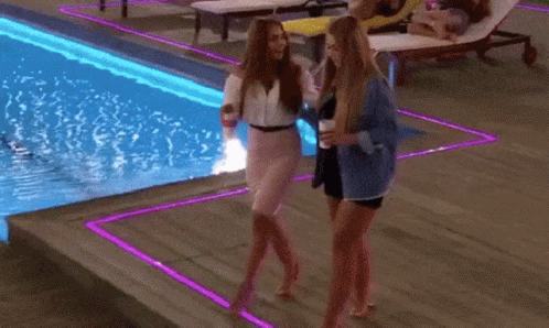A Woman Is Walking A Dog Near A Swimming Pool GIF