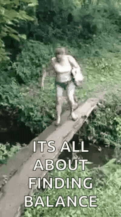 A Woman Is Walking Across A Small Wooden Bridge Over A Stream . GIF