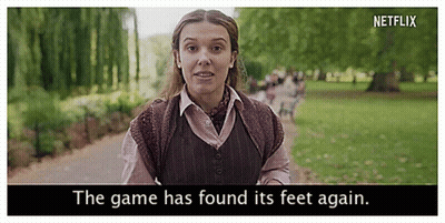 A Woman Is Walking Down A Path In A Park With The Words `` The Game Has Found Its Feet Again '' . GIF
