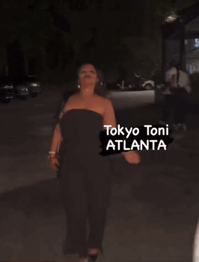 A Woman Is Walking Down A Street With The Words Tokyo Toni Atlanta Written On The Bottom GIF