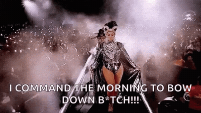 A Woman Is Walking On A Stage In Front Of A Crowd And Says `` Command The Morning To Bow Down B * Tch '' . GIF