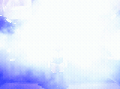 A Woman Is Walking Through A Tunnel Of Smoke And Lights GIF