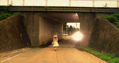 A Woman Is Walking Under A Bridge On A Road . GIF