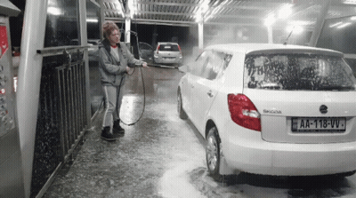 A Woman Is Washing A White Skoda Car With A License Plate That Says Aa-118-Vv GIF