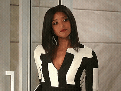 A Woman Is Wearing A Black And White Dress With A Plunging Neckline . GIF
