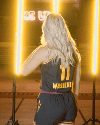 A Woman Is Wearing A Black Jersey With The Number 11 On It GIF