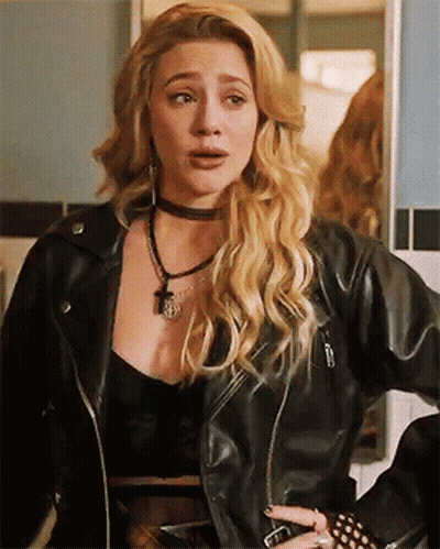 A Woman Is Wearing A Black Leather Jacket And A Choker Necklace . GIF