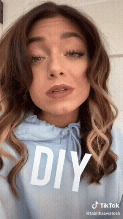 A Woman Is Wearing A Blue Hoodie With The Word Diy On It GIF