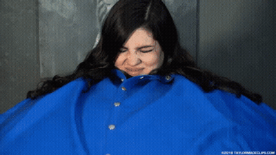 A Woman Is Wearing A Blue Jacket That Is Very Big GIF
