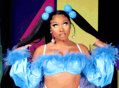 A Woman Is Wearing A Blue Top With Feathers And Pigtails In Her Hair . GIF