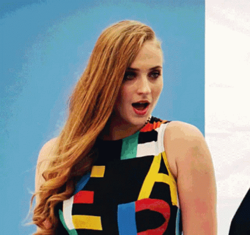 A Woman Is Wearing A Colorful Dress With The Letter E On It GIF