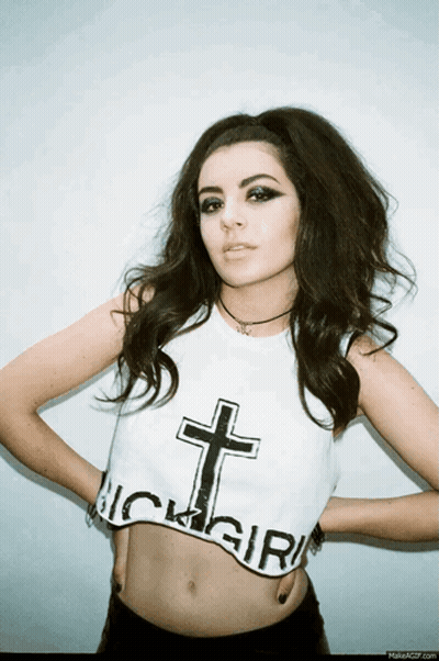A Woman Is Wearing A Crop Top With A Cross On It And The Word Girl On It GIF