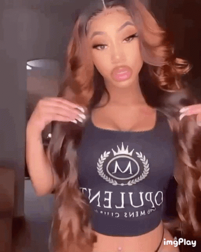 A Woman Is Wearing A Crop Top With The Letter M On It GIF