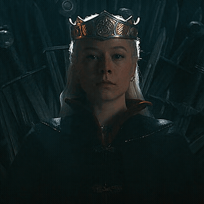 A Woman Is Wearing A Crown And A Black Cape GIF
